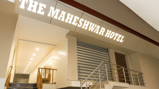 The exterior of The Maheshwar Hotel with a prominent sign, a staircase with metal railings, and a modern design. - The Maheshwar Hotel (Varanasi)