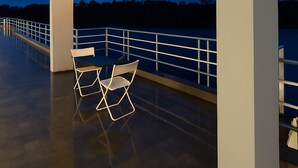 An outdoor terrace with a white pergola structure, two chairs, and a railing. - River Splash Resort Neral Karjat (Karjat)