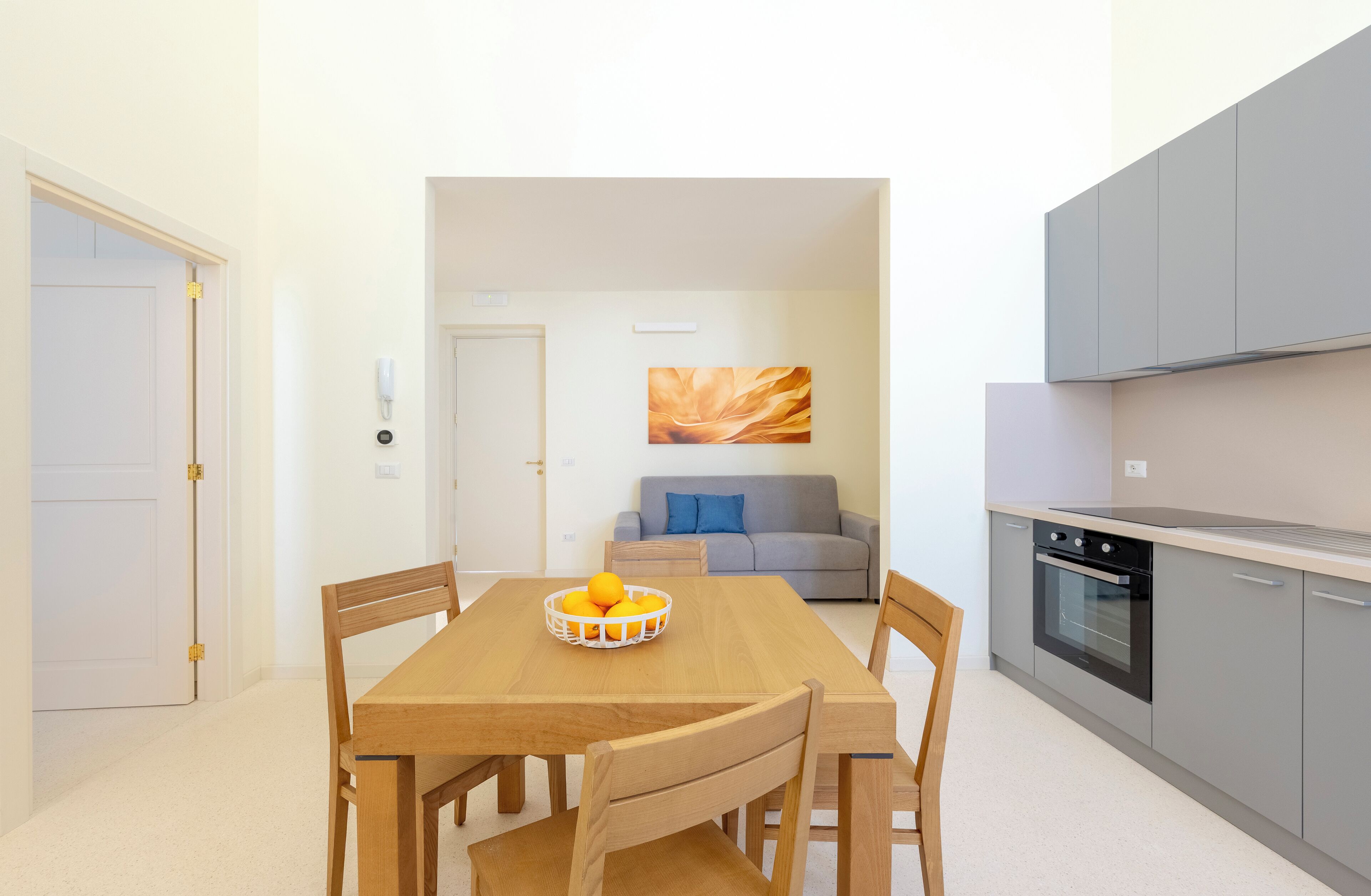A modern kitchen with grey cabinets and a built-in oven.