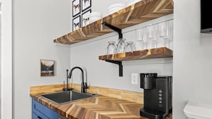 Una cocina moderna con encimera de madera, un grifo negro y una cafetera.