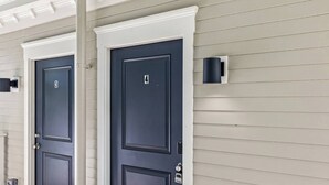 Two dark-colored doors with numbers 3 and 4, white trim, and a security keypad on the right door.
