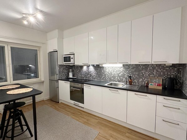 Apartamento Confort | Cocina privada | Frigorífico grande, microondas, horno y placa de cocina