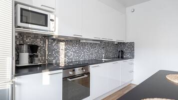 Comfort appartement | Privékeuken | Een koelkast met diepvriezer, een microgolfoven, een oven, een kookplaat