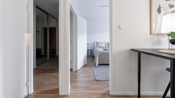 Un dormitorio moderno con cama, mesita de noche y un cuadro en la pared.