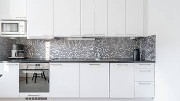 Apartamento Confort | Cocina privada | Frigorífico grande, microondas, horno y placa de cocina