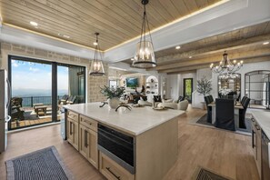 Una cocina amplia con una isla grande, techo de madera e iluminación colgante.