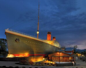 A large ship with the name 'Titanic' prominently displayed, docked at a port with a small building labeled 'White Star' nearby.