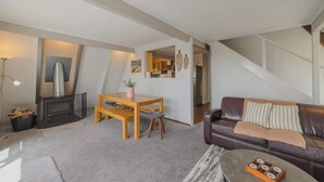 Una sala de estar acogedora con chimenea, un comedor y un sofá de cuero.