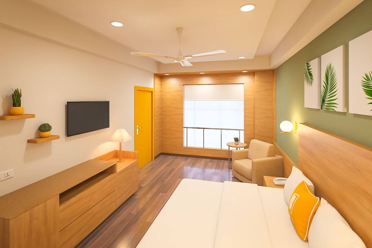 Una habitación de hotel moderna con cama, televisión, escritorio, silla y balcón con vistas.