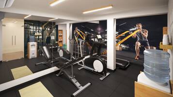 A modern gym with various exercise equipment, a water dispenser, and a large mirror.