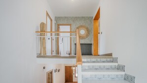 A staircase with a wooden handrail, a round wall decoration, and a radiator. - Country House in Torrecaballeros with Mountain Views, Private Pool, and Wi-Fi (Torrecaballeros)
