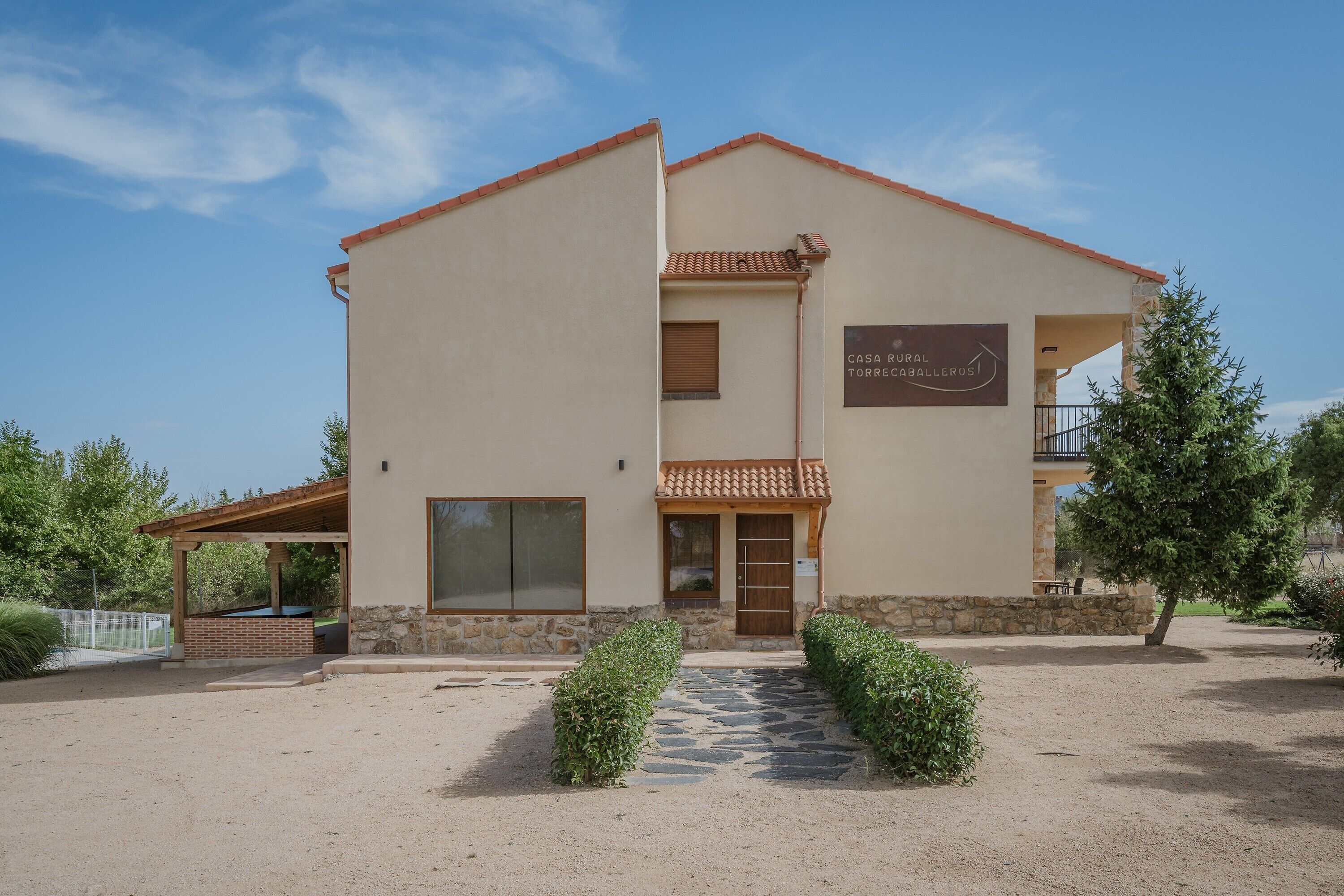 Un edificio de dos pisos con un cartel que indica 'CASA RURAL TORRECHABEROS'.