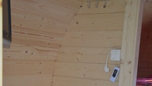 Una sauna de madera con bancos y panel de control.