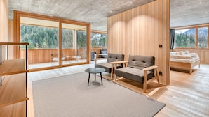 A modern interior with a wooden floor, a sofa, a coffee table, and a bed. - Studa 29 - Studa 6 in Brand (Brand)