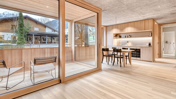 Eine moderne Küche mit Holzschränken und einem Essbereich mit Tisch und Stühlen.