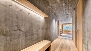 A hallway with a wooden bench, concrete walls, and a wooden door at the end. - Studa 29 - Studa 2 in Brand (Brand)