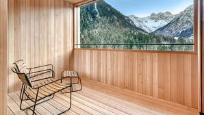A wooden deck with a bench and a large window overlooking a mountainous landscape. - Studa 29 - Studa 10 in Brand (Brand)