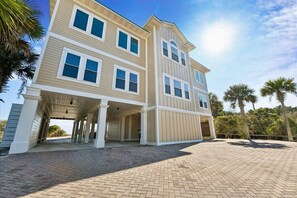 A two-story house with a covered porch and a paved driveway.