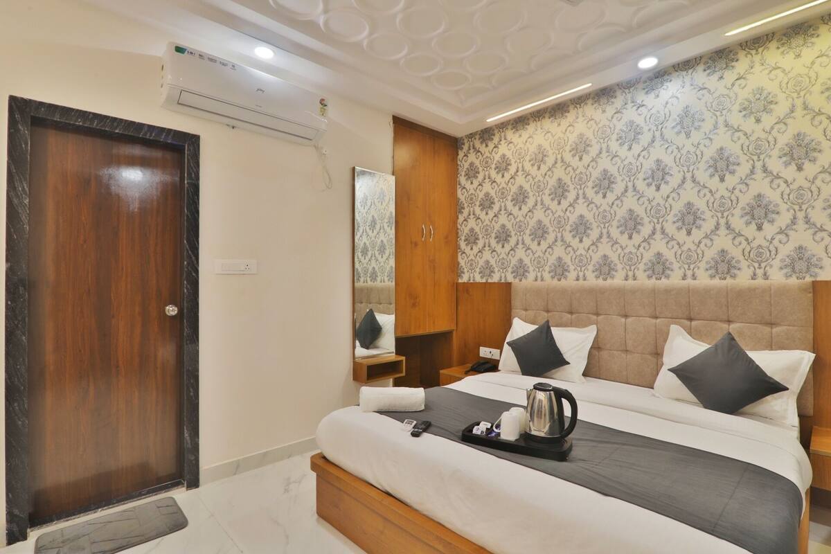 A hotel room with a bed, bedside table, and a wardrobe.