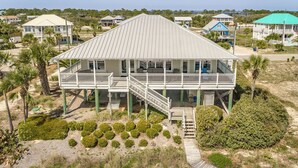 A two-story house with a balcony, a covered porch, and a wooden deck. - Welcome to Salty Dawg! (Eastpoint)