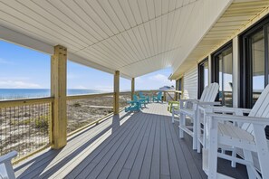 A wooden deck with chairs and a railing overlooking the beach. - Welcome to Dapper Dolphin! (St. George Island)