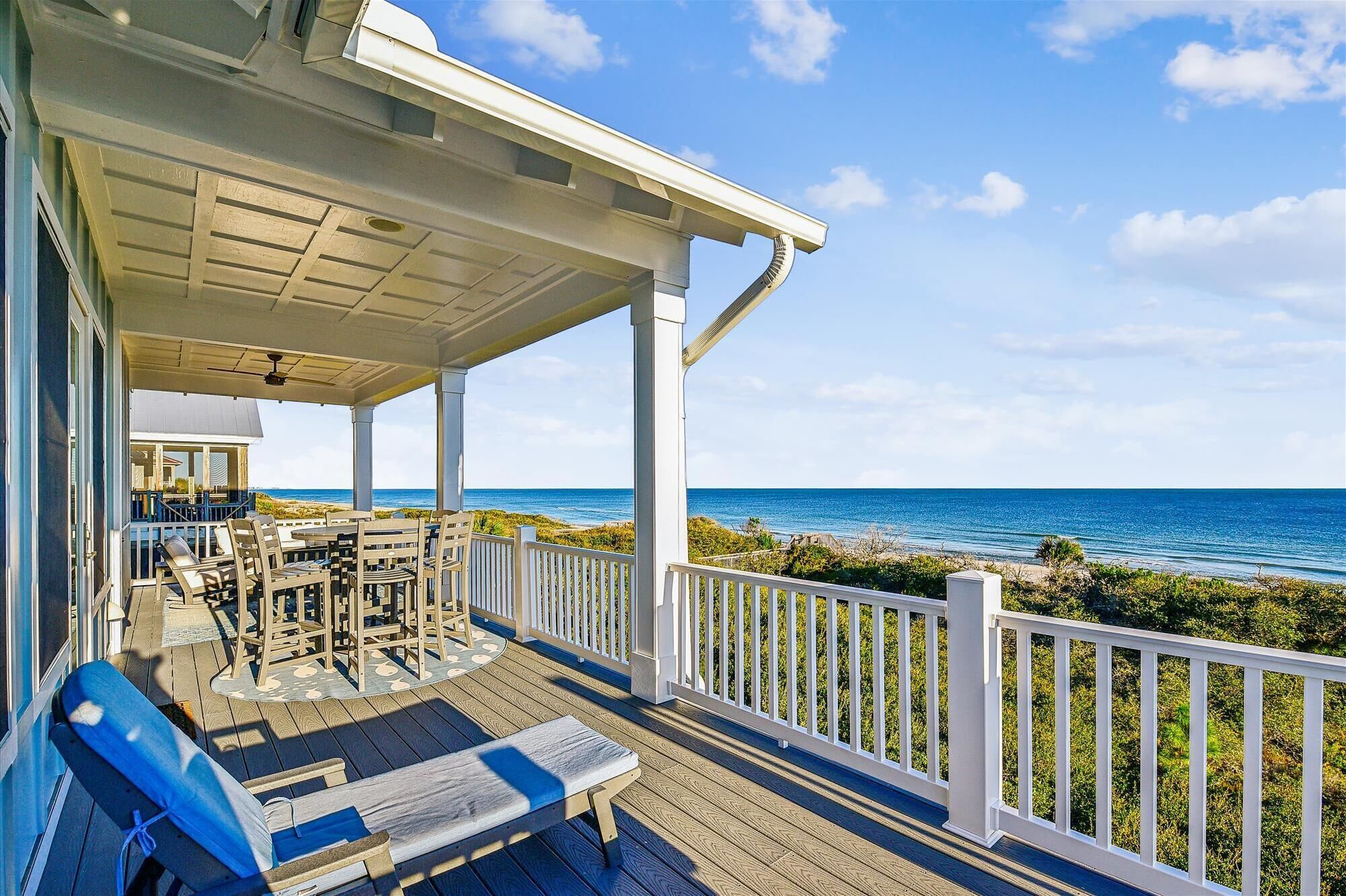 A covered outdoor seating area with a view of the ocean.