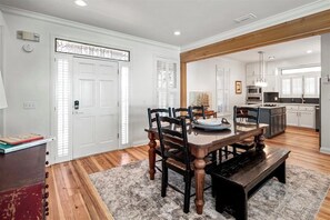 A dining area with a wooden table and chairs, a bench, and a rug. - Welcome to DUNE IT RIGHT! (St. George Island)