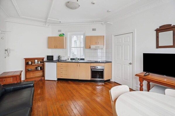 A modern kitchen with wooden cabinets, a built-in oven, and a large window.