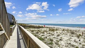A wooden boardwalk leading to a beach with a clear sky. - Welcome to Ocean Mile H-8! (St. George Island)