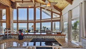 A spacious kitchen with large windows, a central island, and a ceiling fan. - Welcome to Island Dream, where dreams come true! (St. George Island)