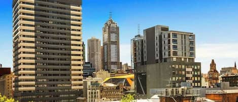 Un paysage urbain avec des immeubles modernes de grande hauteur, dont l’un présente une structure incurvée particulière et l’autre une façade plate.