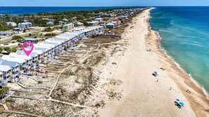 An aerial view of a beachside resort with rows of beach houses, a sandy beach, and the ocean. - Welcome to Aboard the Katie Leigh! (St. George Island)