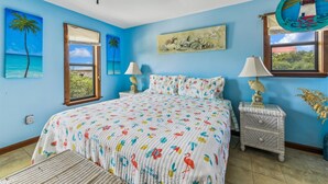 A bedroom with a bed, two bedside tables, a hanging chair, and a window with a view. - Welcome to Brief Escape! (St. George Island)