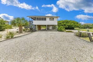 A two-story house with a covered porch and a gravel driveway. - Welcome to Brief Escape! (St. George Island)