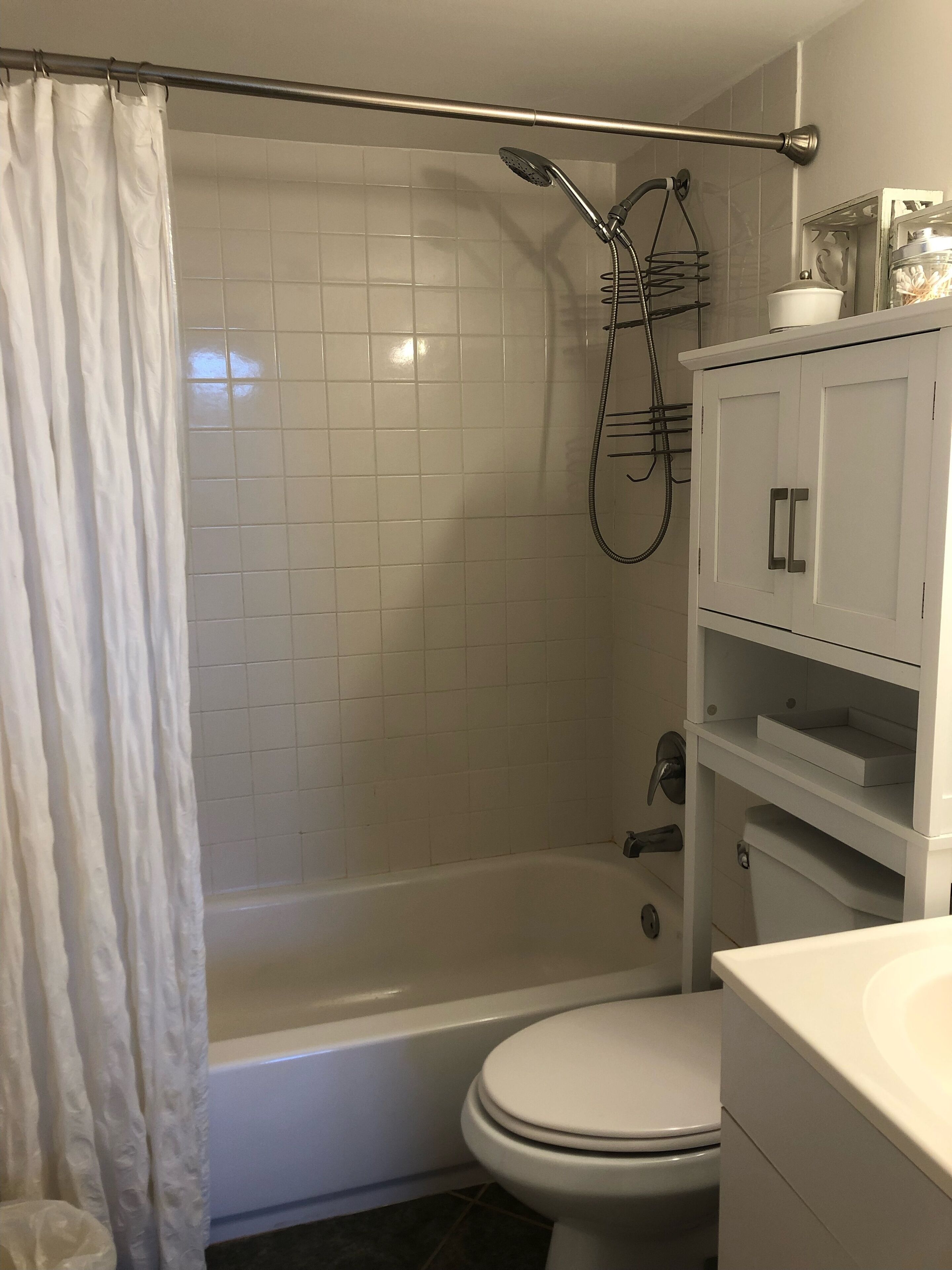 Une salle de bain avec une douche, des toilettes et un meuble blanc.