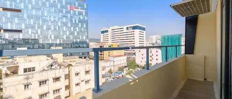 A balcony with a view of a cityscape, including modern and older buildings.