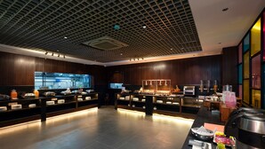 A modern breakfast area with a central counter, buffet with various food items, and a coffee station. - Ira by Orchid Hyderabad Hitech City Mindspace IT Park (Hyderabad)