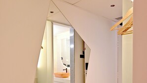 A modern interior with a staircase, a bathroom with a sink and mirror, and a wooden door. - Ira by Orchid Hyderabad Hitech City Mindspace IT Park (Hyderabad)