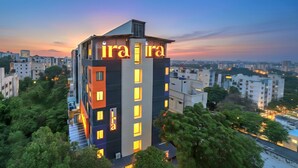 A modern hotel with a prominent 'ira' sign, surrounded by greenery and other buildings. - Ira by Orchid Hyderabad Hitech City Mindspace IT Park (Hyderabad)