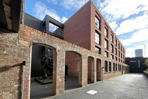 A building with a brick facade, large windows, and an arched entrance.