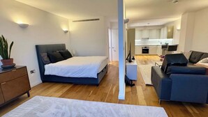 Une chambre à coucher moderne avec un lit, une table de chevet et une plante en pot.
