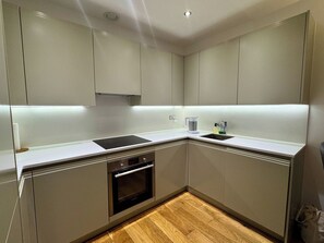 A modern kitchen with a built-in oven, a sink, and a countertop.
