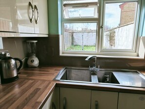A kitchen with a sink, a kettle, and a blender. - Bright 3BD House Near East Croydon Station (Greater London)