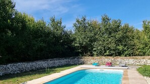 A rectangular swimming pool with a wooden deck surrounding it. - Le Figuier:8-person gite, heated pool and leisure facilities 25 minutes from Futuroscope. (Mazeuil)