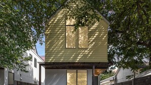 A two-story house with a garage, surrounded by a gravel driveway and wooden fences. - Austin Luxury 5BR Modern House | ACL x Formula 1 (Austin)