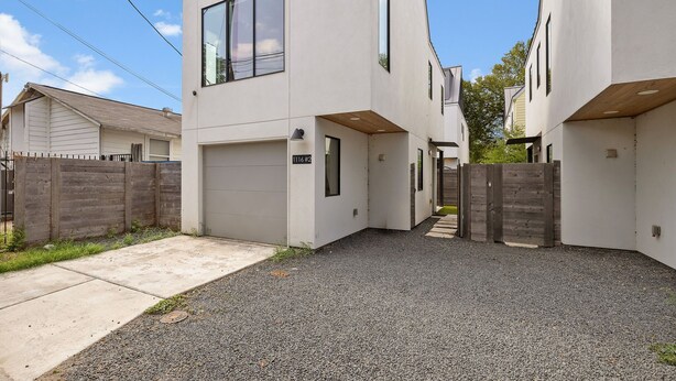 A modern two-story house with a garage and a gravel driveway. - Austin Luxury 5BR Modern House | ACL x Formula 1 (Austin)