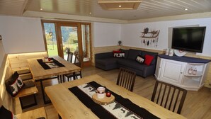 Una sala de estar acogedora con un sofá, una mesa de comedor y un televisor.