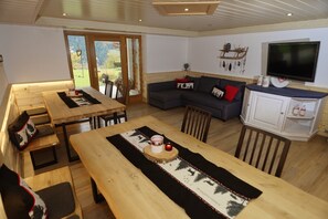 Una sala de estar acogedora con un sofá, una mesa de comedor y un televisor.