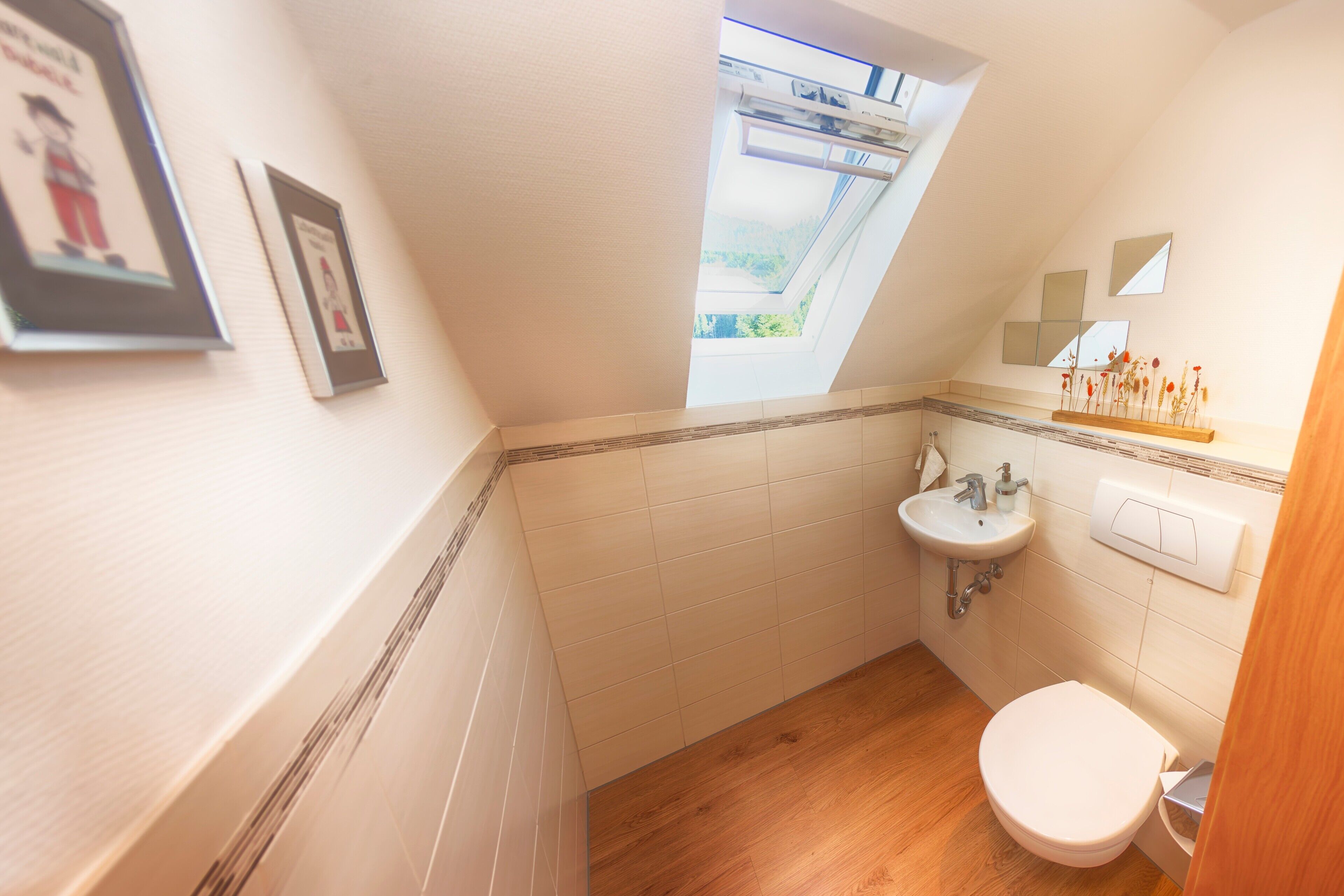 A small bathroom with a skylight, a sink, and a toilet.