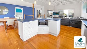 Una cocina moderna con armarios blancos, una encimera azul y un microondas integrado.